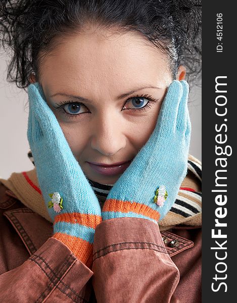 A girl in a striped scarf and blue gloves. A girl in a striped scarf and blue gloves