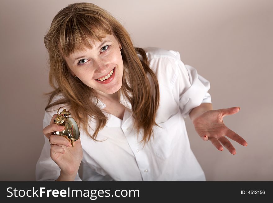 A nice woman in a white shirt holding an alarm-clock. A nice woman in a white shirt holding an alarm-clock