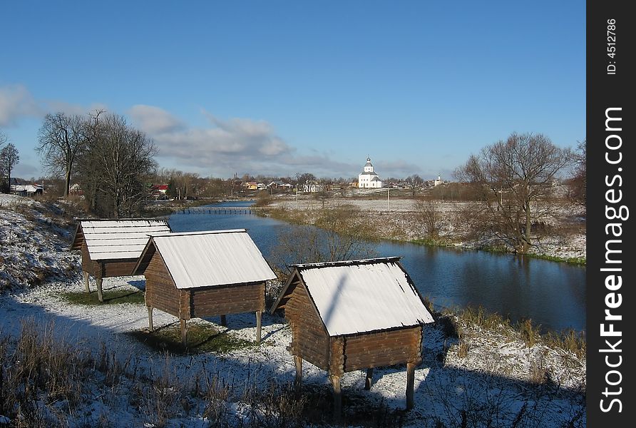 Typical Russian country landscape - wooden architecture and church on coast of the river.