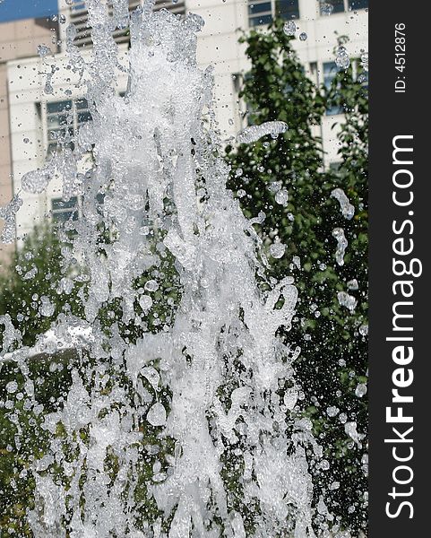 Fragment of fountain water drops in the air, with little bubbles in them.