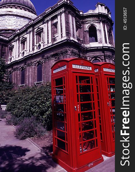 Old red telephones with old building background. Old red telephones with old building background