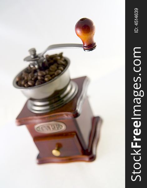 A nice small coffee grinder with coffee seeds. A nice small coffee grinder with coffee seeds