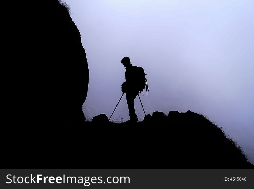 Young man walking in a mountain on a foggy day. Young man walking in a mountain on a foggy day.