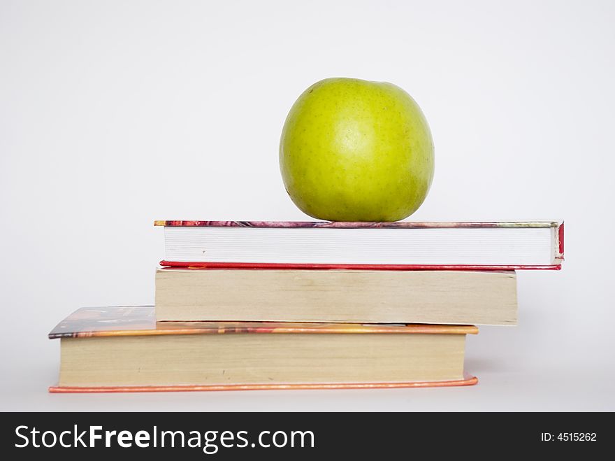 Green apple and stack of books