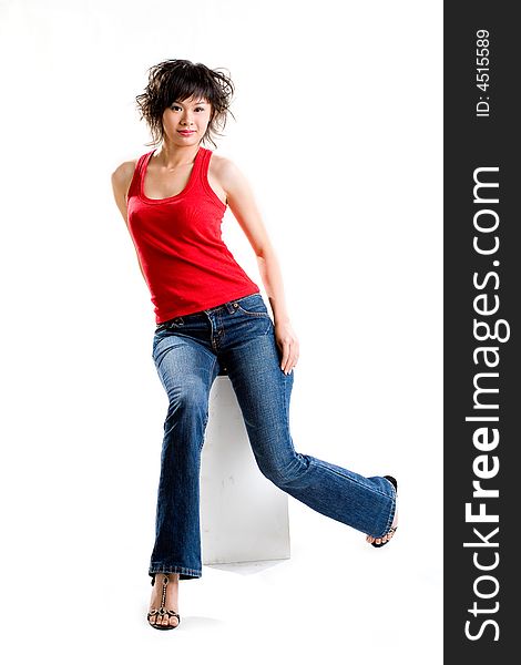 Happy young woman sit and pose in jeans