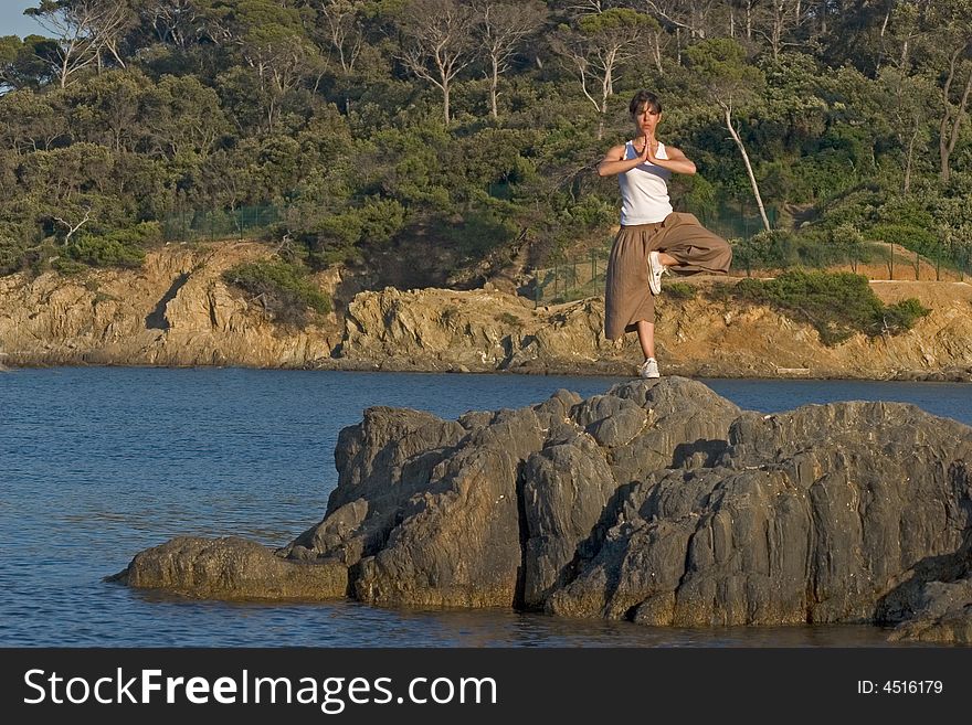 Woman making of yoga at the seaside. Woman making of yoga at the seaside