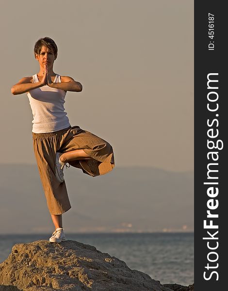 Woman making of yoga at the seaside. Woman making of yoga at the seaside