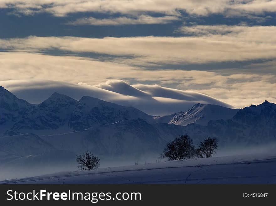 High mountains, tree and big white clouds