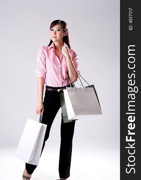 Young woman happily shopping full of paper bags. Young woman happily shopping full of paper bags