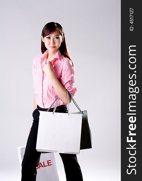 Young woman happily shopping full of paper bags. Young woman happily shopping full of paper bags