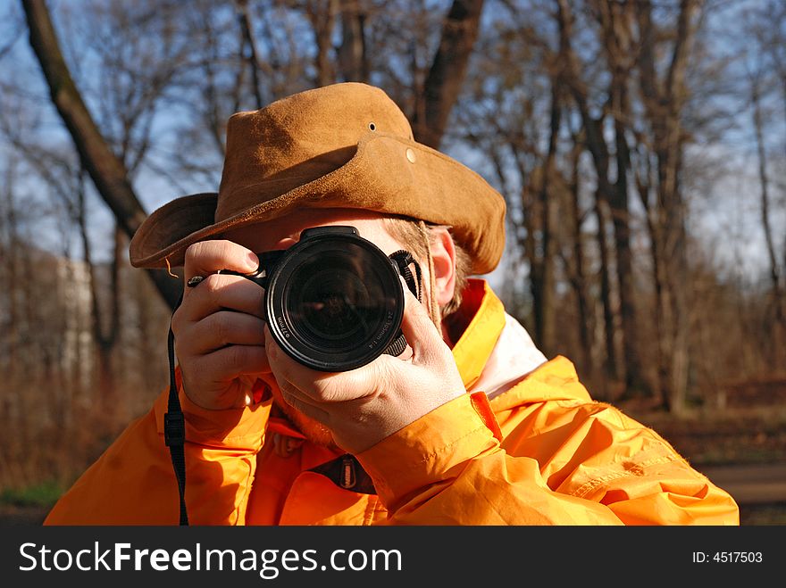 Young man taking picture outdoor, forest in background. Young man taking picture outdoor, forest in background.