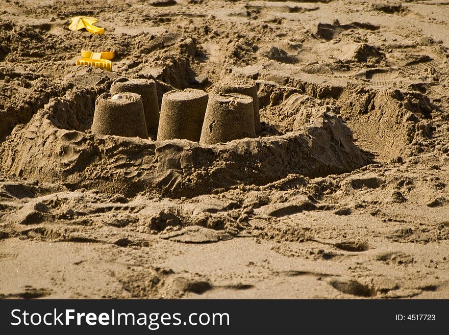 A spade and sandcastle built on a british beach in the height of the summer holidays. A spade and sandcastle built on a british beach in the height of the summer holidays