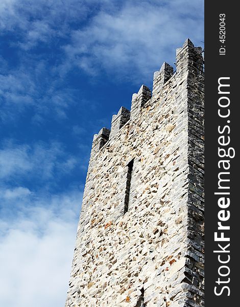 Detail of Medieval Castle tower against cloudy blue sky