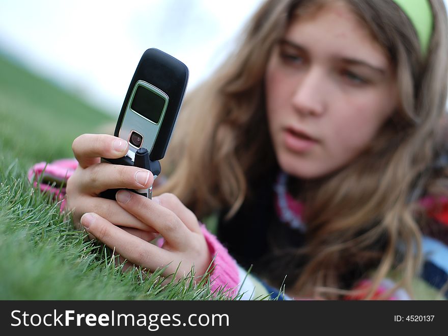 Young blond girl in the park and cell phone. Young blond girl in the park and cell phone