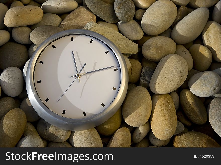 Big white clock over round peebles