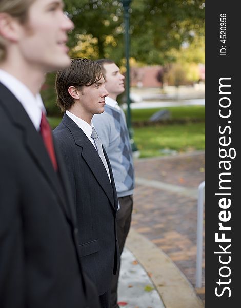 Three business men standing and smiling in same direction. Three business men standing and smiling in same direction