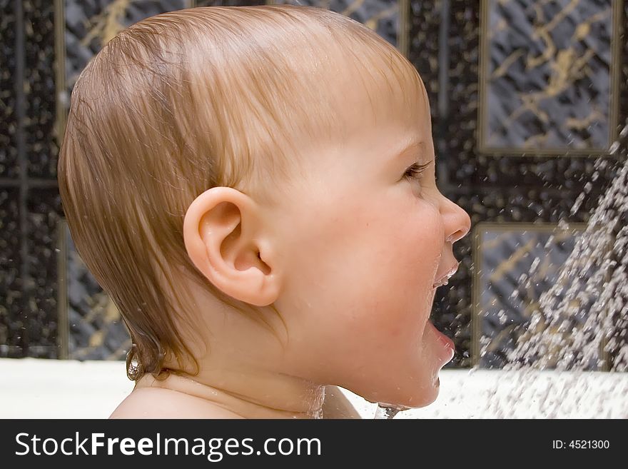 Bathing and smiling baby under the douche. Bathing and smiling baby under the douche