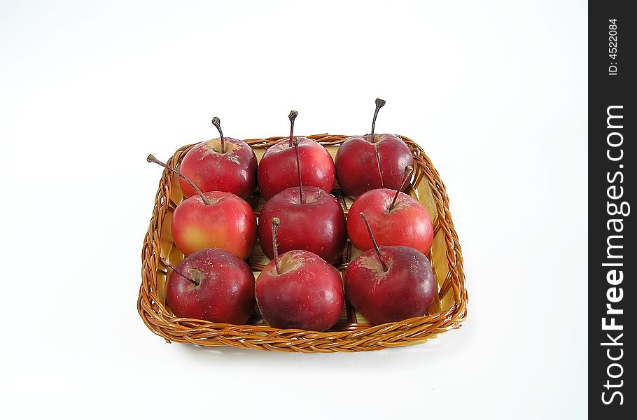 Red apples in a straw basket. isolated.