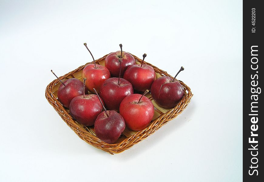 Red apples in a straw basket. isolated.