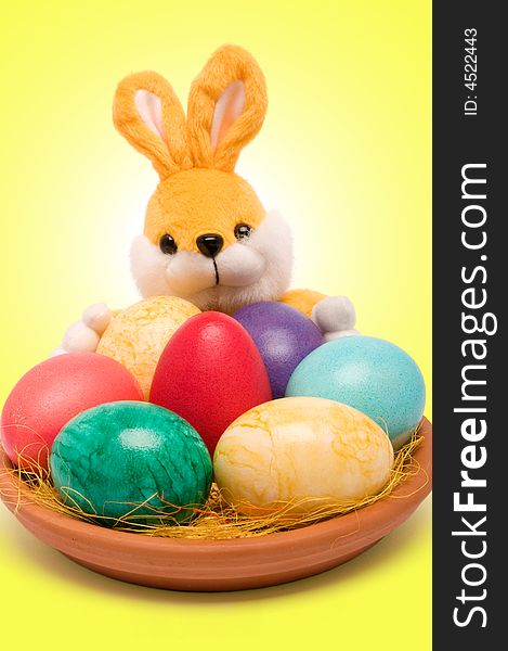 Easter colored eggs on a plate with rabbit. Easter colored eggs on a plate with rabbit.