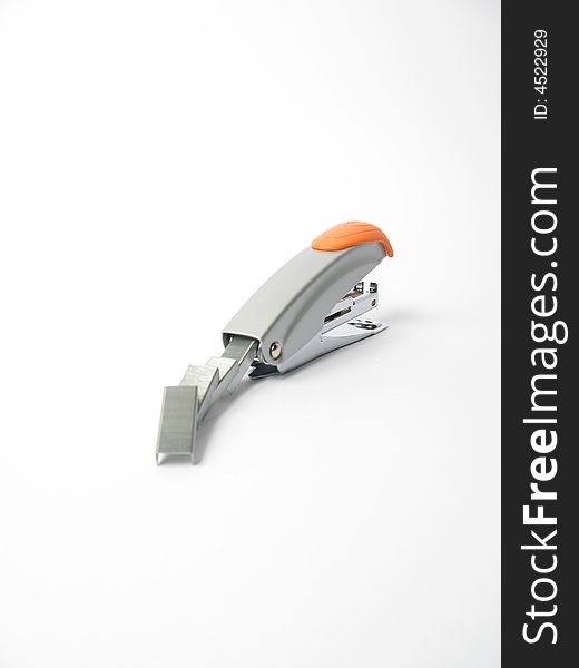 Silver and orange Stapler with staples on white background