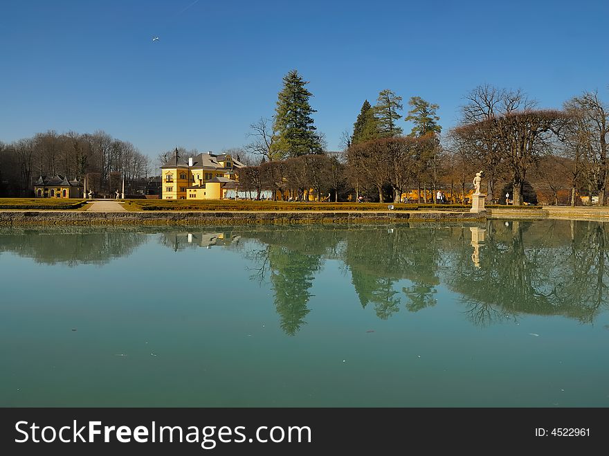 Palace Hellbrunn and reflection of a statue in a pond. Palace Hellbrunn and reflection of a statue in a pond