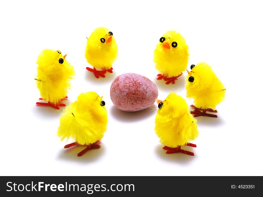 A group of easter chicks surrounding an egg. A group of easter chicks surrounding an egg