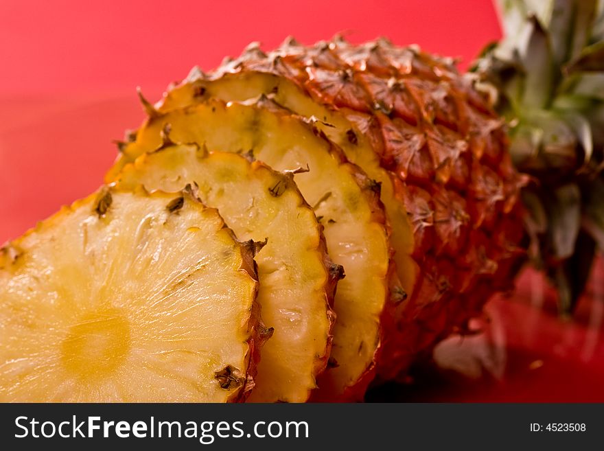 Food series: fresh ripe pineapple over red strawberry on the plate