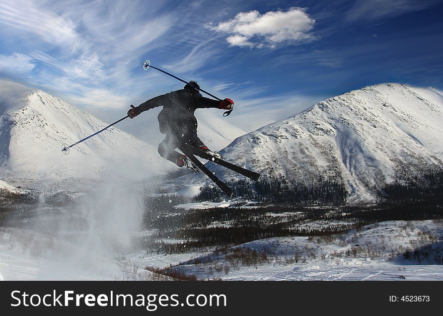 The skier in mountains in flight from a back has jumped from a springboard