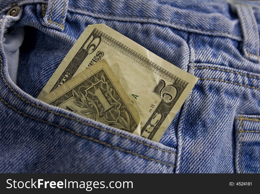 A one and five dollar bill in US currency in jeans pocket. A one and five dollar bill in US currency in jeans pocket.