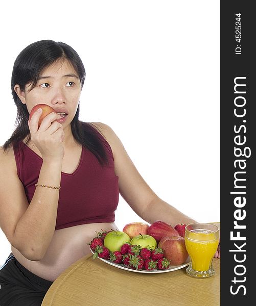 A pregnant women eat her apple with white background