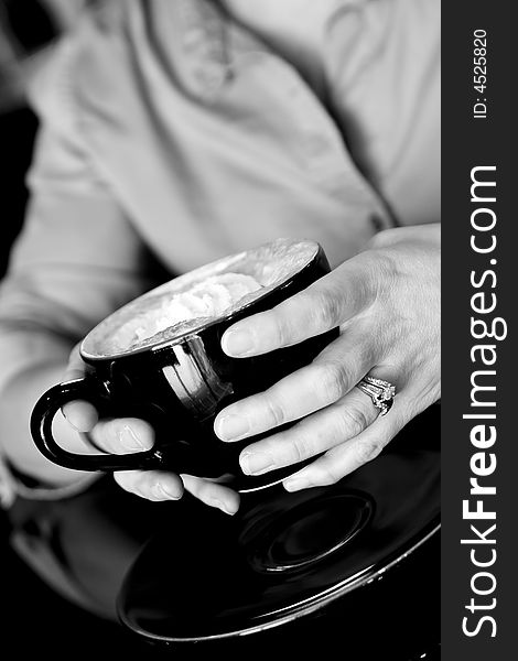 Womans hands holding coffee with whipped cream