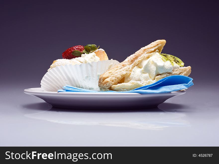 Cream pies on a plate on transparent violet background