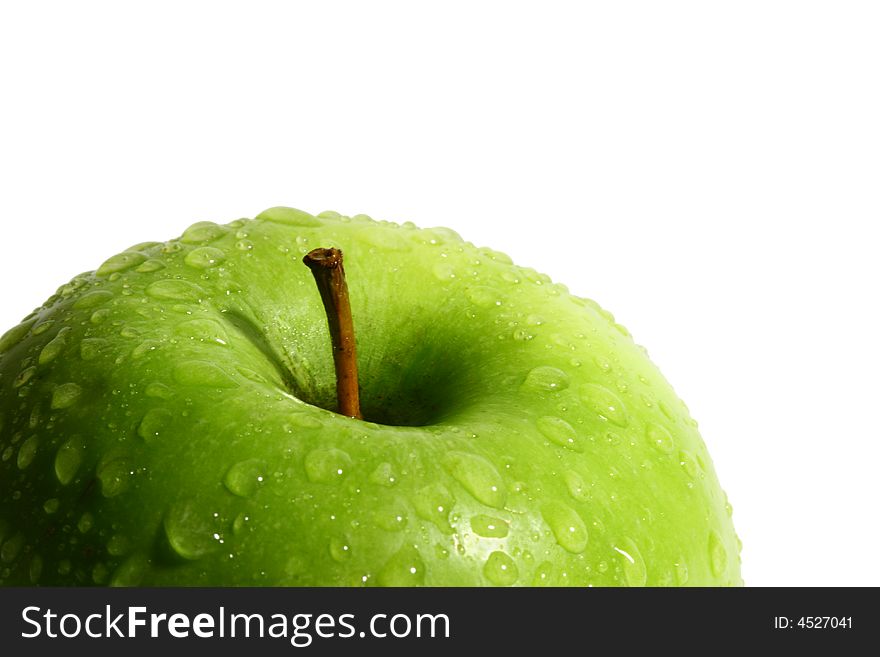 The green apple is covered by water drops