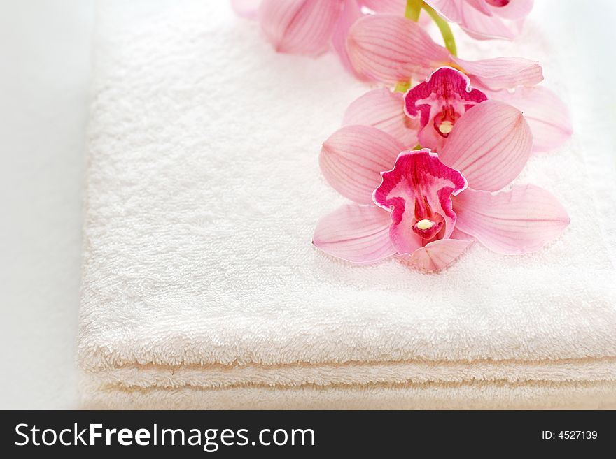 Two white towels with a pink orchid. Two white towels with a pink orchid