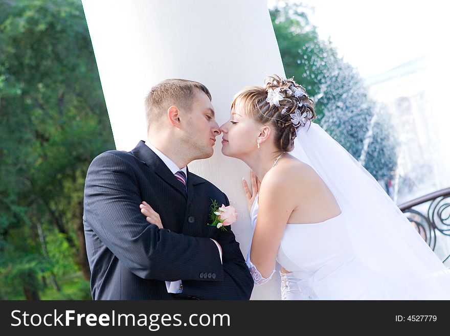 Kiss of the newly-married couple in the columns. Kiss of the newly-married couple in the columns