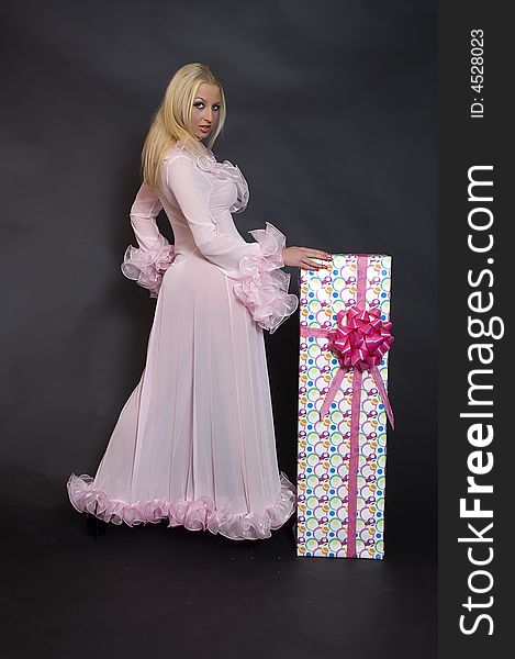 Girl standing in pink robe next to a rapped box pink bow