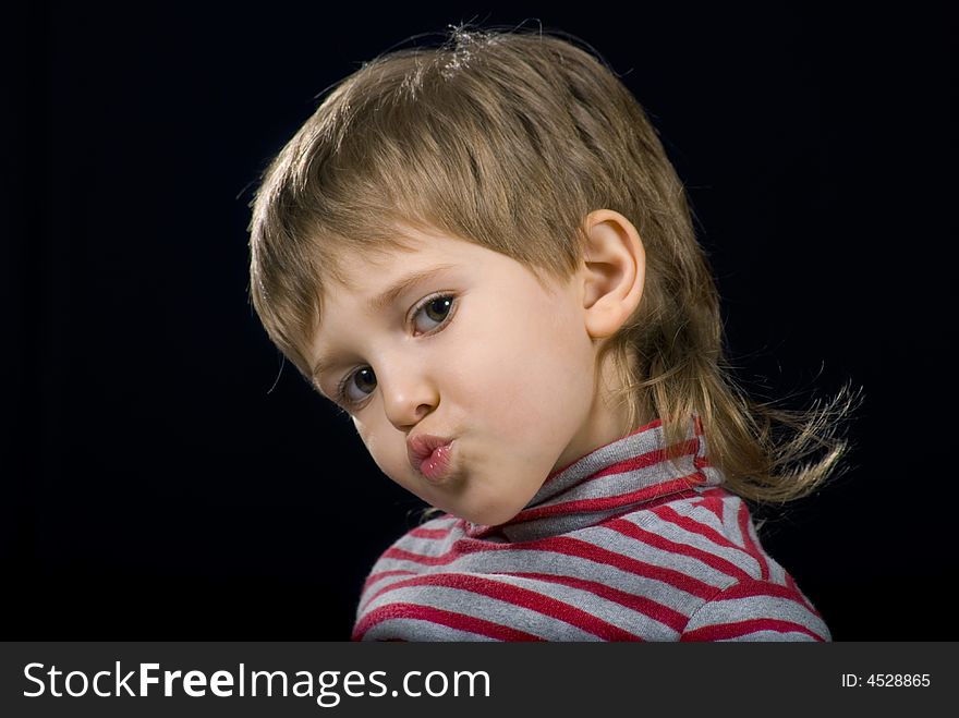 Grimace of Little boy on a black background. Grimace of Little boy on a black background