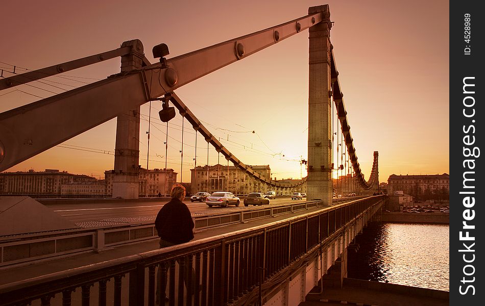 The Solitary man, going on bridge toward. Evening, Moscow, Russia. The Solitary man, going on bridge toward. Evening, Moscow, Russia