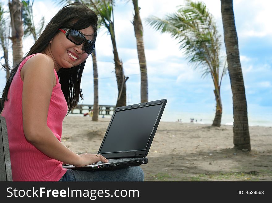 Girl and laptop at the beach