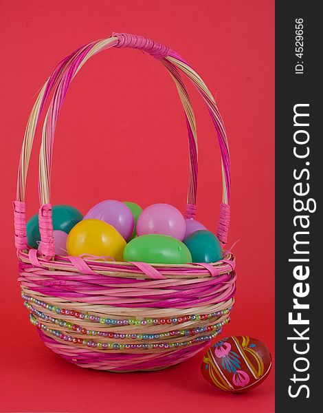 A basket full of plastic eggs (to be filled with candy) and pisanka egg on a side. A basket full of plastic eggs (to be filled with candy) and pisanka egg on a side