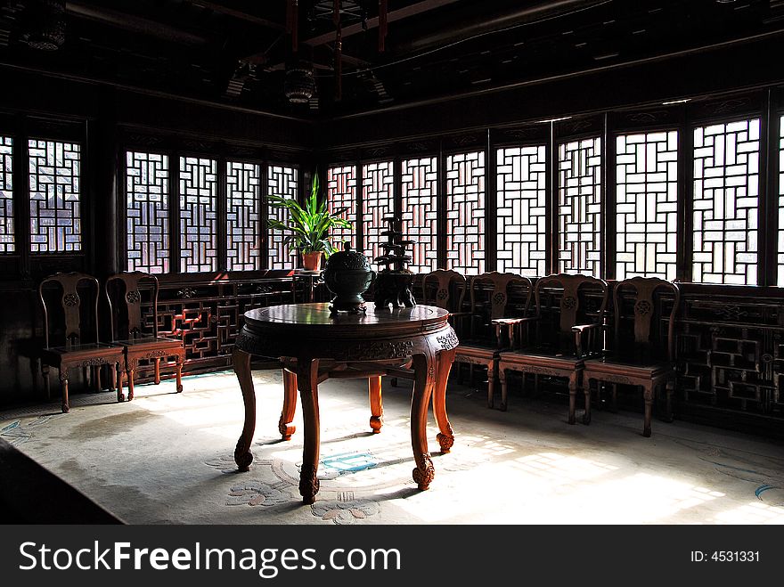 Traditional Chinese sittingroom with old desks, chairs and incense burner on desk