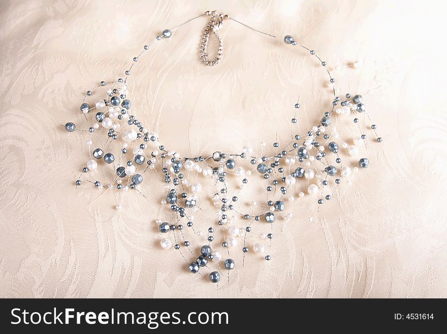 Pearls necklace on satin cushion