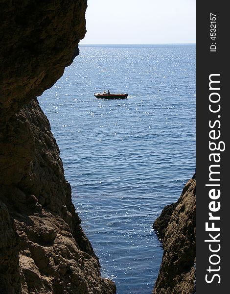 Motorboat sails seaborne, is seen from cave