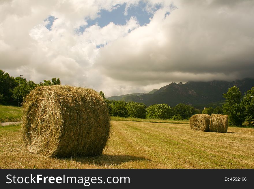 Haystacks Under A Moody Sky