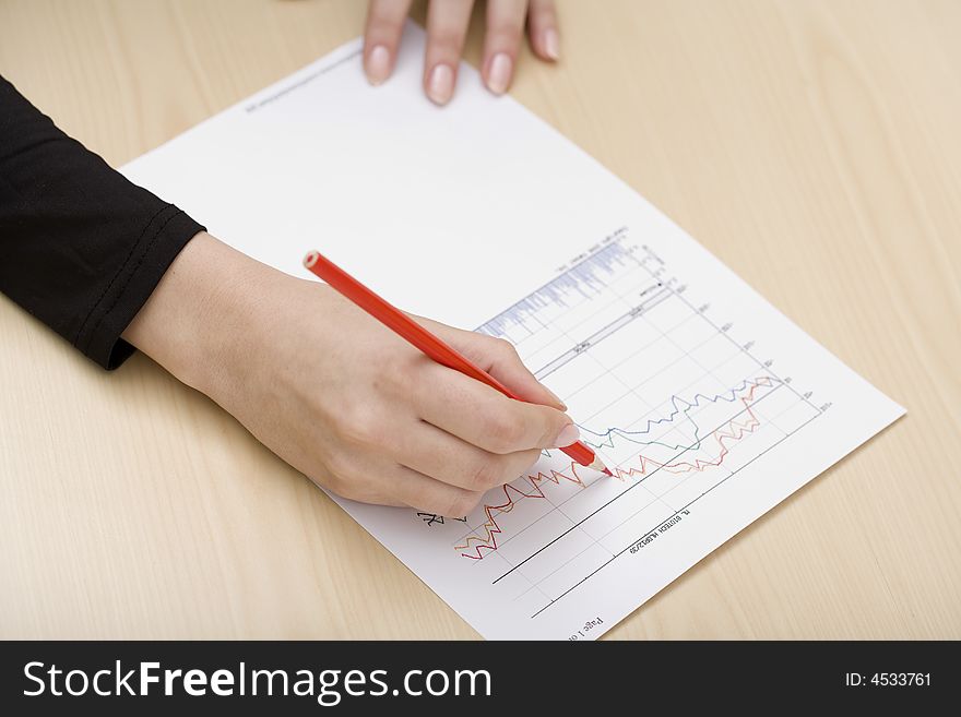 Woman drawing a graph with a red pencil