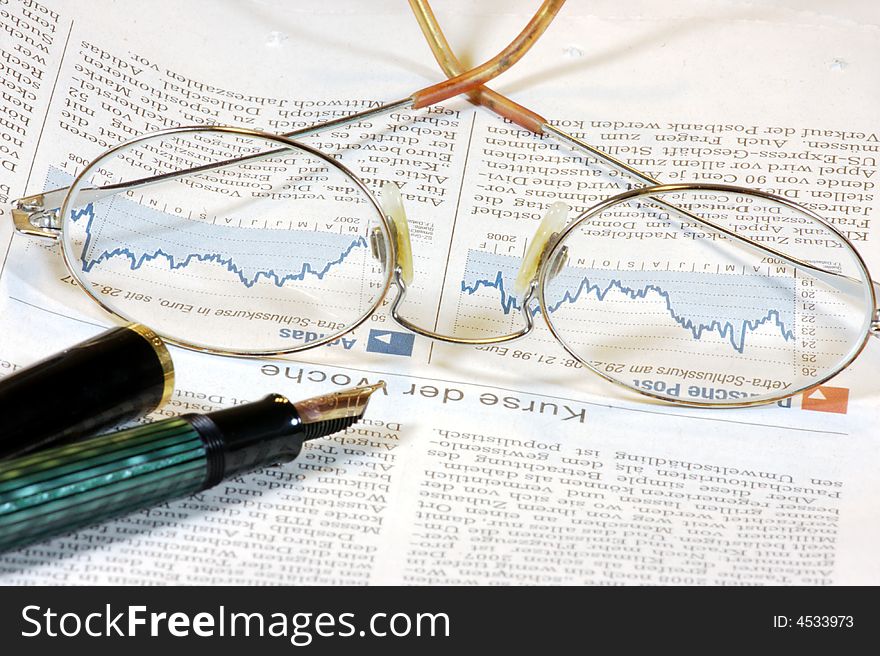 Glasses, a stock chart and a pen. Glasses, a stock chart and a pen