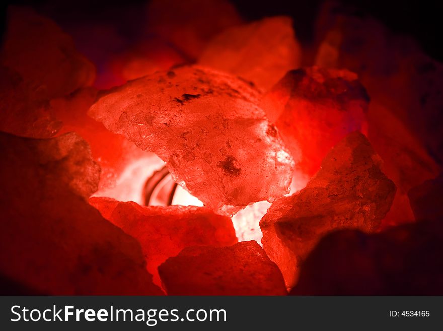 Red coloured stones coals in the light close up