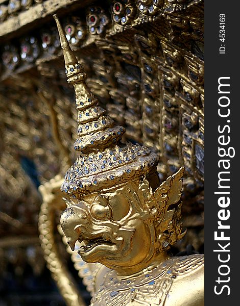 Golden statue of a daemon on a temple in Thailand