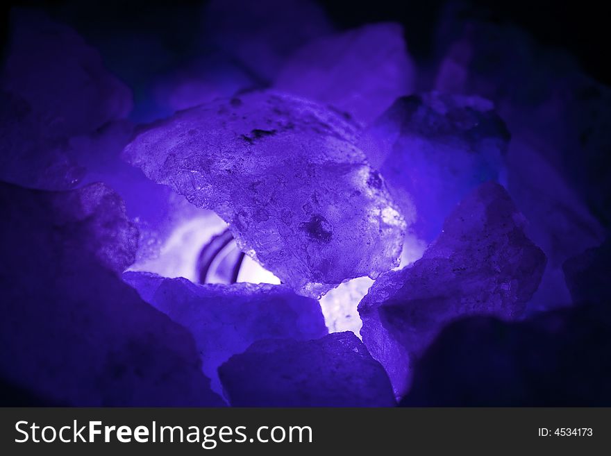Purple blue stones coals in the light close up